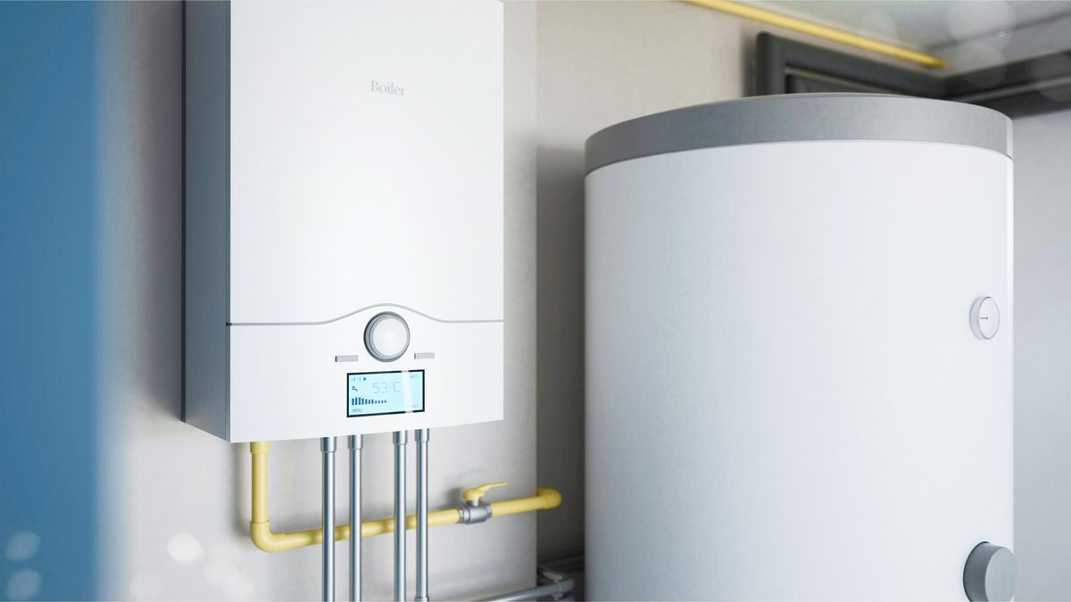 Weißes Wandgerät mit Display und mehreren Rohren neben einem großen weißen zylindrischen Boiler mit grauem Deckel.