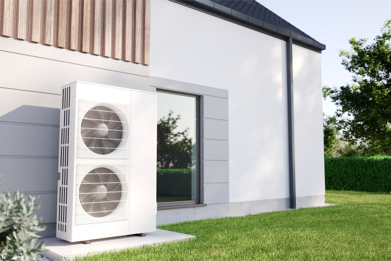 Weiße Wärmepumpe mit zwei großen Lüfterrädern steht neben modernem Haus mit weißer Fassade und großem Fenster.